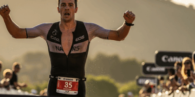 male triathlete crossing a finish line at a scenic outdoor t 20260331 081838